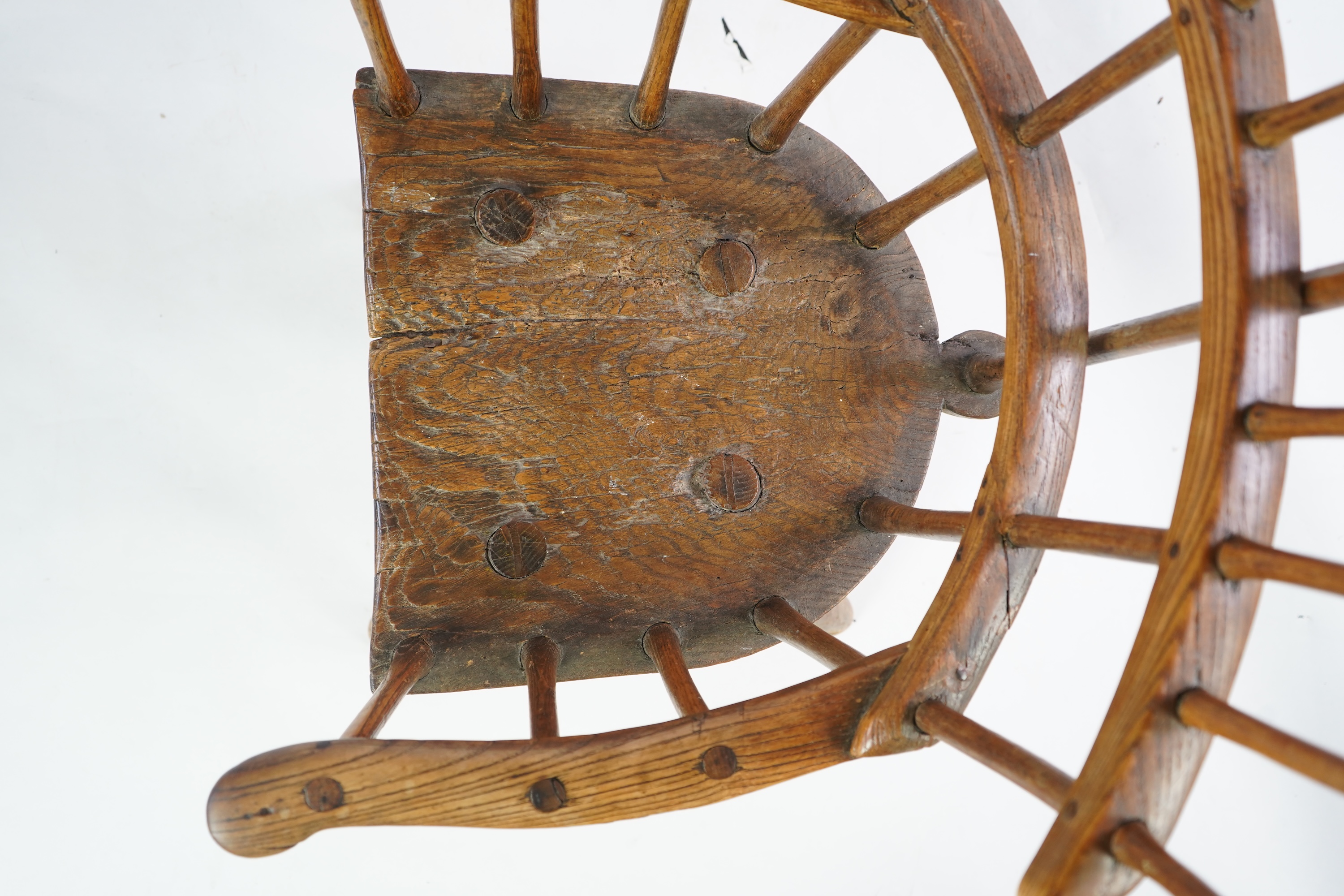 An 18th or 19th century primitive ash and elm Windsor armchair